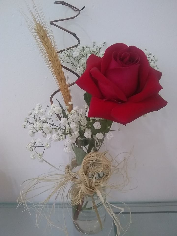 Botão solitário de rosa no vasinho de vidro